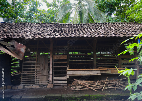 A rustic livestock shelter for cows or goats, surrounded by lush greenery and trees. a simple yet vital space for livestock care in the countryside