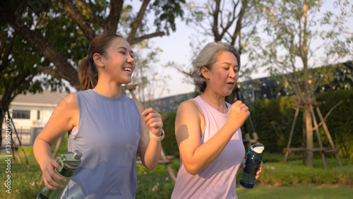Young adult child workout outdoor public park run walk hold water bottle with mature middle age old mum. Love health care older mom asia elder people happy family protect aging fun joy city life sport