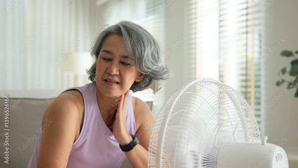 Asia adult people middle age old woman sit at sofa home feel hot flash fever use fan waving hand blowing wind face elder health care summer heat aging issue. Sad pain sweat tired stroke suffer stress. Asia adult people middle age old woman sit at sofa home feel hot flash fever use fan waving hand blowing wind face elder health care summer heat aging issue. Sad pain sweat tired stroke suffer stress.