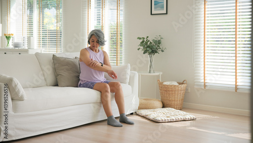 Foto Asia adult people middle age old woman itch leg arm elbow body dry skin hand touch neck stress sad pain sit at home elder health care aging beauty illness issue