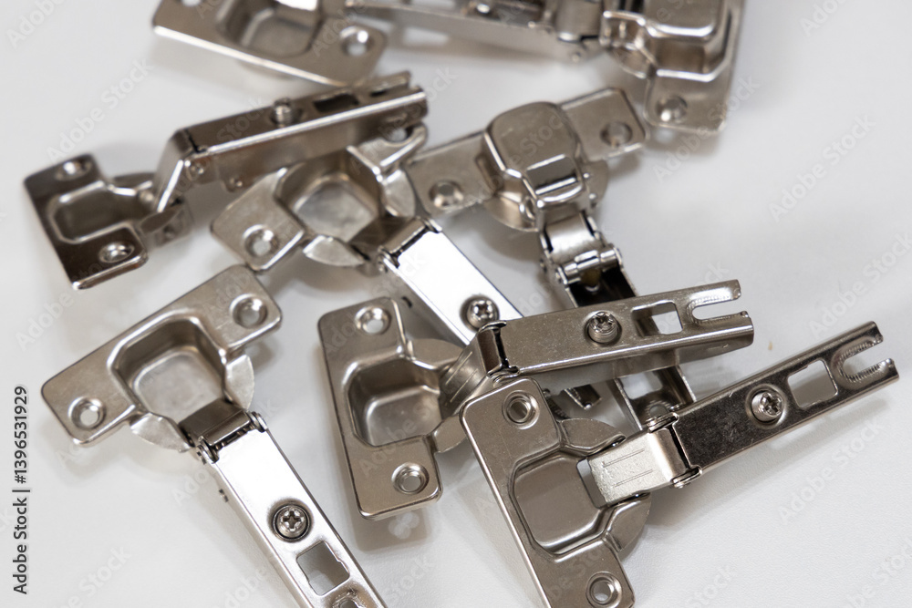 Metal hinges for a wardrobe cabinet shown in close-up. Suitable for illustrating furniture fittings, DIY assembly, and home renovation themes. Metal hinges for a wardrobe cabinet shown in close-up. Suitable for illustrating furniture fittings, DIY assembly, and home renovation themes.