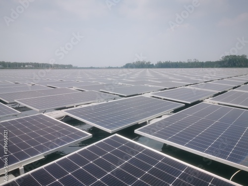 A large number of solar panels are installed on gray plastic pontoons over a body of water.