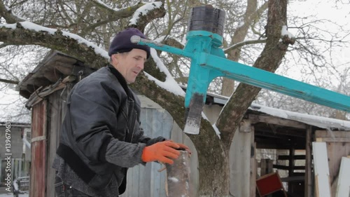 chopping firewood with mechanical wood splitter, mechanical wood splitter for chopping firewood, senior man chops wooden blocks