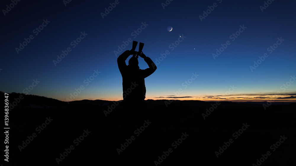 Amateur astronomer looking at the evening skies, observing planets, stars, Moon and other celestial objects with binoculars.