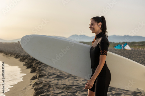 Canvas Print Young woman enjoying surfing on sandy beach