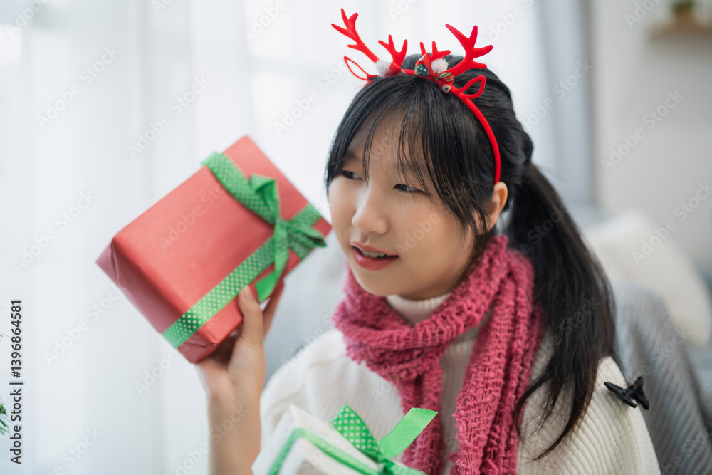 Joyful Girl with Christmas Antlers and Red Present, Celebrating Festive Season with Cheerful Expressions and Cozy Winter Accessories at Home Joyful Girl with Christmas Antlers and Red Present, Celebrating Festive Season with Cheerful Expressions and Cozy Winter Accessories at Home