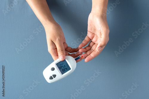 Woman's hands checking diabetes and hyperglycemia with digital blood sugar meter. Healthcare and medical concept	 photo