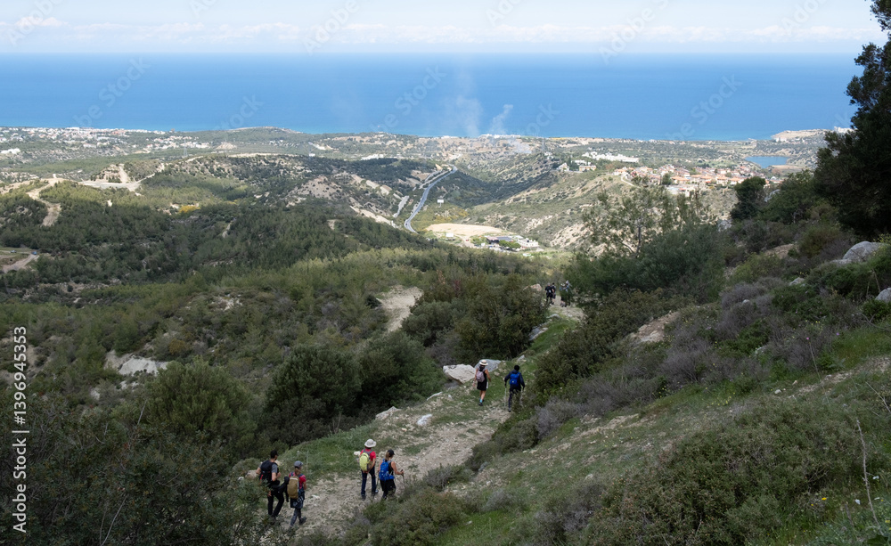 Obraz premium People hiking downhill enjoying breathtaking mediterranean sea view in cyprus