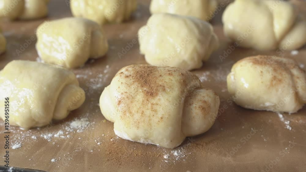 The raw buns are sprinkled with cinnamon. Sweet pastries. The raw buns are sprinkled with cinnamon. Sweet pastries.