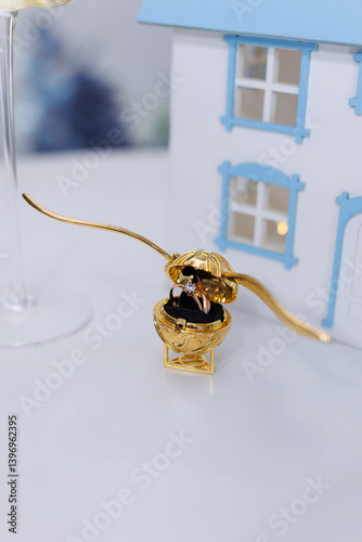 Foto A golden snitch jewelry box with wedding rings.