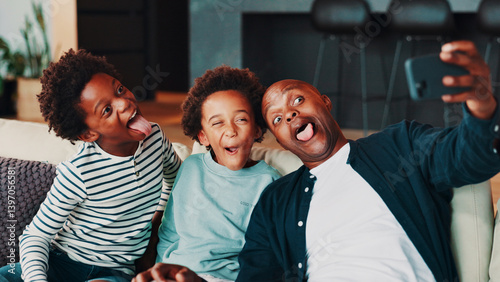 Tableau sur toile Selfie, silly and dad with children on sofa for social media, profile picture and online post in home