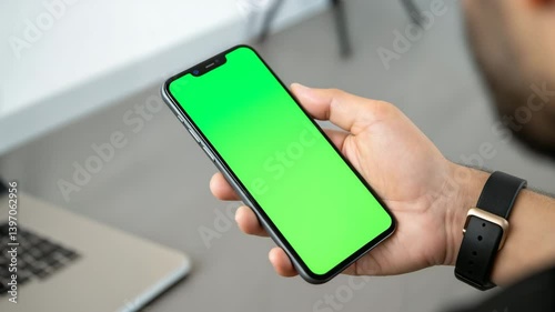 Man holding smartphone with green screen for chroma key and mockup presentation