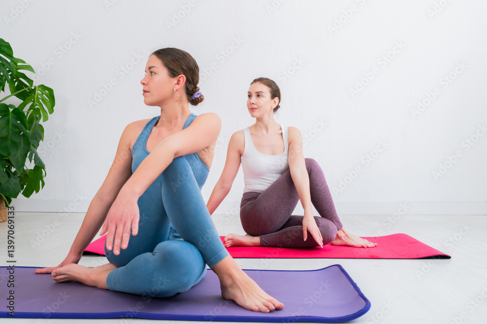 Two women practicing yoga poses together in a serene indoor space, focusing on relaxation and mindfulness during a group exercise session for wellness and mental clarity Two women practicing yoga poses together in a serene indoor space, focusing on relaxation and mindfulness during a group exercise session for wellness and mental clarity