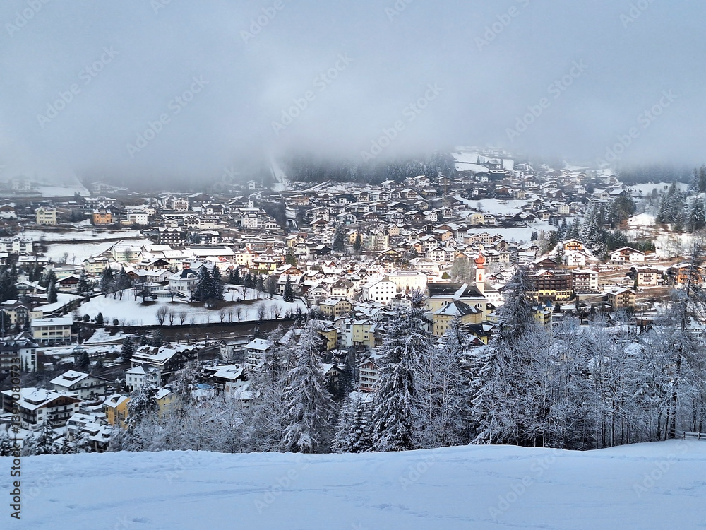 Fototapeta premium Top view of winter Ortisei in snowy fog.