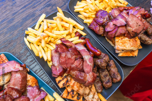 Delicious Grilled Meat Platter With Crispy French Fries On Rustic Wooden Table photo