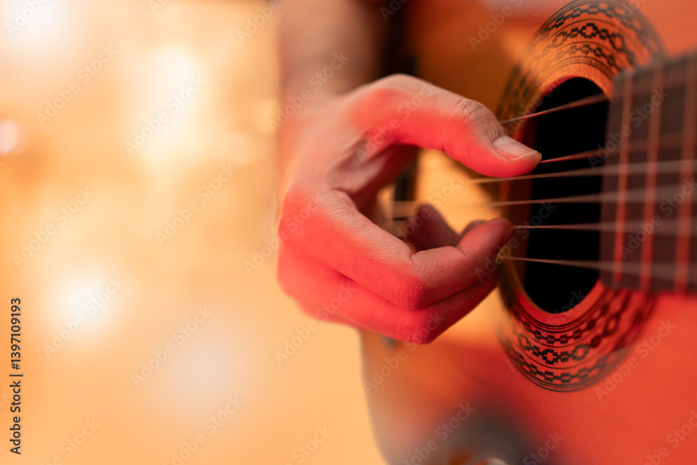 Fototapeta premium An unrecognizable man playing an acoustic guitar on the stage