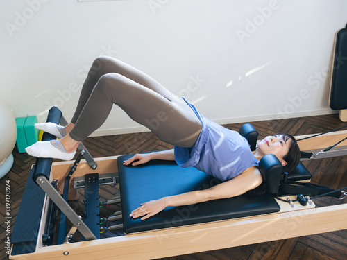 マシンピラティスのトレーニングをする女性