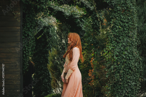 Side view of woman in romantic peach dress standing under green arch, with eyes closed. Concept of secret longing, soft beauty, emotional stillness. Suitable for fantasy novel or movie.