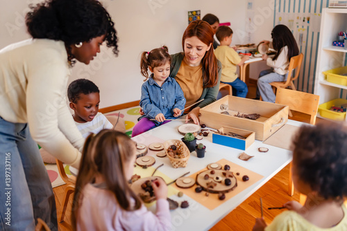 Bilde på lerret Curious preschool children explore nature objects with a teacher during a hands-