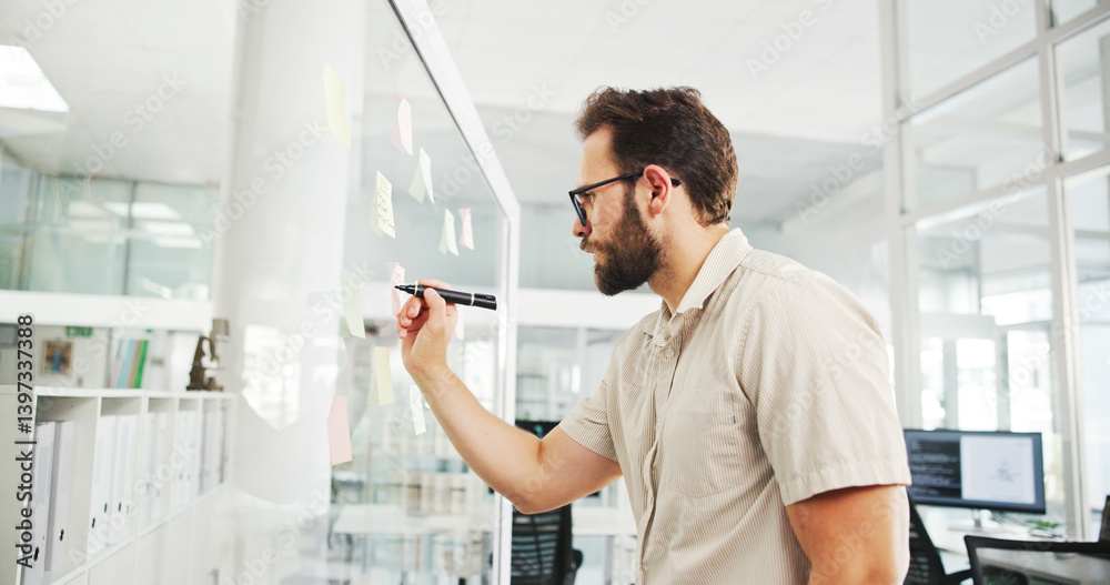Fototapeta premium Business, glass wall and man in office, writing and decision with brainstorming for proposal. Person, employee and sales consultant in workplace, problem solving and planning for project or choice