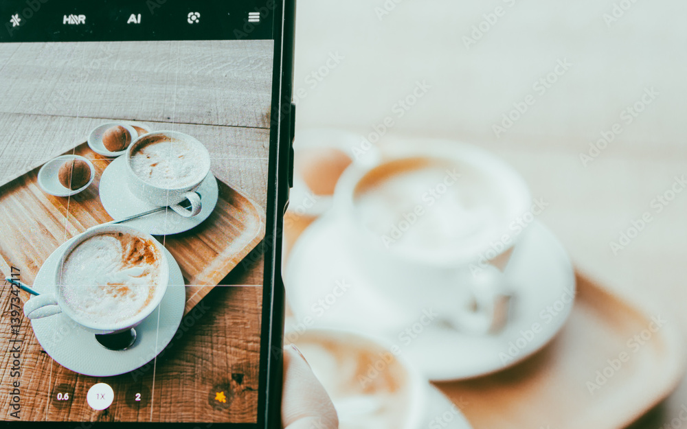 Making a phone photo of two white coffee cups with sweet pastry. Breakfast flat lay on phone screen. Make a photo of morning aroma coffee and dessert for social media. Americano with milk and biscuits