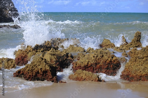 Sea waves splashing over reef rocks at edge of water in Tabatinga beach, close to Joao Pessoa, Brazil northeast. 