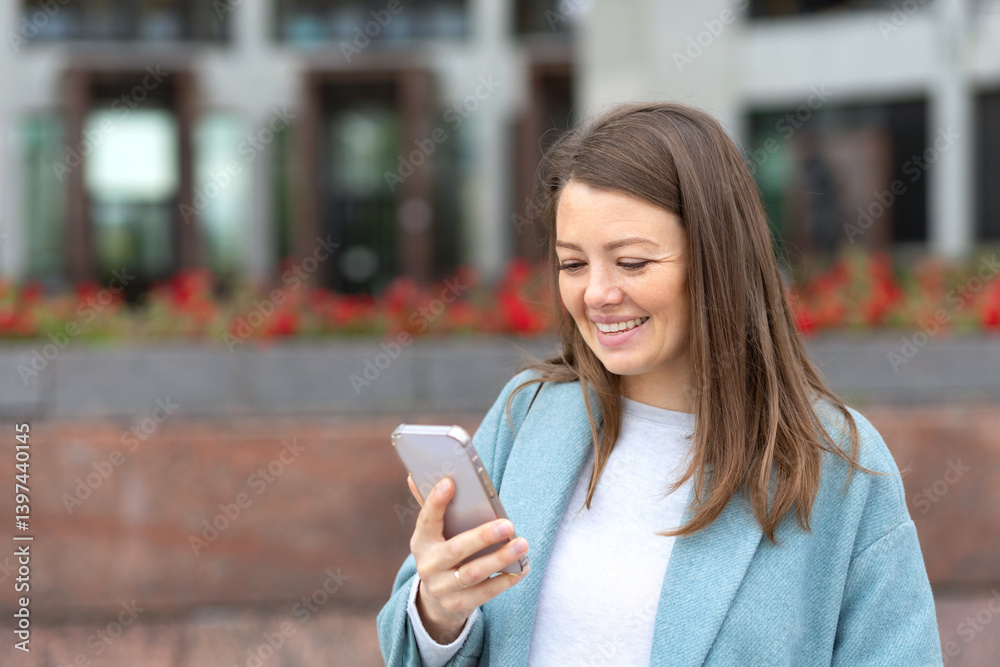 Happy woman receiving good news on phone, reading message in smartphone. Female looking at mobile and smiling. Girl talking via video call outdoor. copy space, text