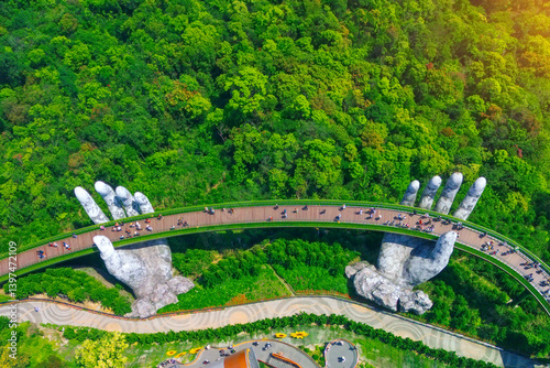 Fototapeta Naklejka Na Ścianę i Meble -  Aerial top view famous tourist attraction among the tropical jungle in the forests - Golden bridge at the top of the Ba Na Hills, Vietnam