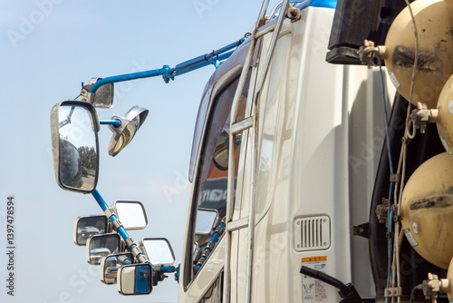Obraz na płótnie The steel holder with rear-view mirrors attached on the cabin of truck riding on the highway. w salonie