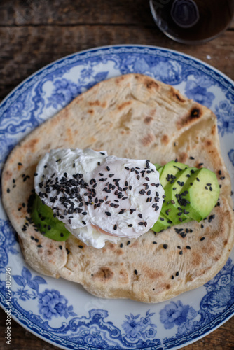 Flatbread with with avocado, poached egg and black sesame