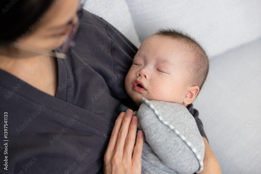 Mother comforting newborn baby to sleep gently