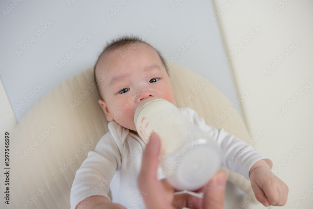 Cute baby drinking milk lying down