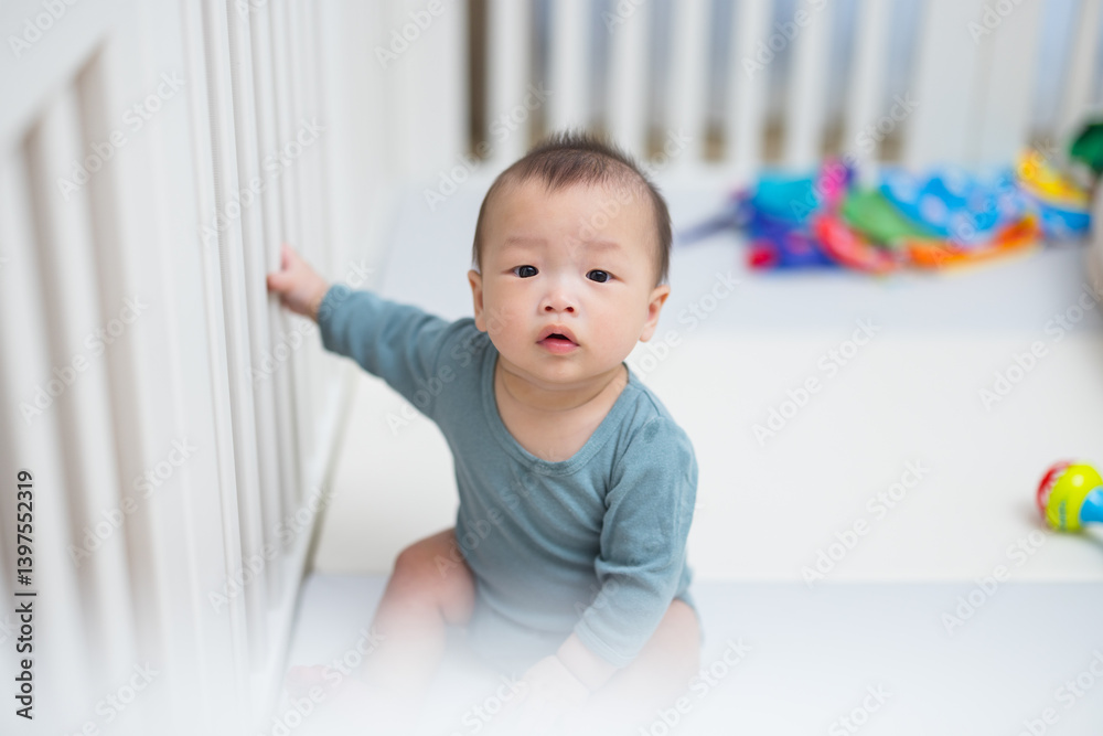 Cute baby sitting inside safe playpen