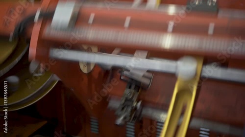 Inside the factory, equipment that wraps cables in insulation. Machinery efficiently transforms raw materials in a bustling factory setting