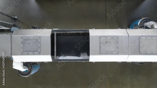 A factory conveyor system seamlessly moves rubber materials along a precise path. The setup demonstrates effective industrial automation and material handling processes in action.