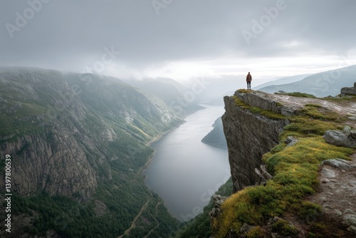 Obraz na płótnie A breathtaking norwegian landscape with a person posing on a cliff overlooking a serene lake w salonie
