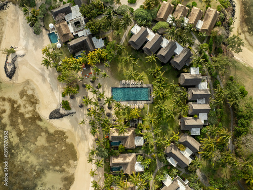 Aerial view of luxurious beachfront resort with swimming pool and palm trees, prince maurice, flacq, mauritius. photo