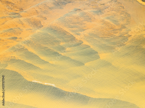 Aerial view of beautiful glacial river with abstract patterns and serene landscape, Hvolsvollur, Southern Region, Iceland.