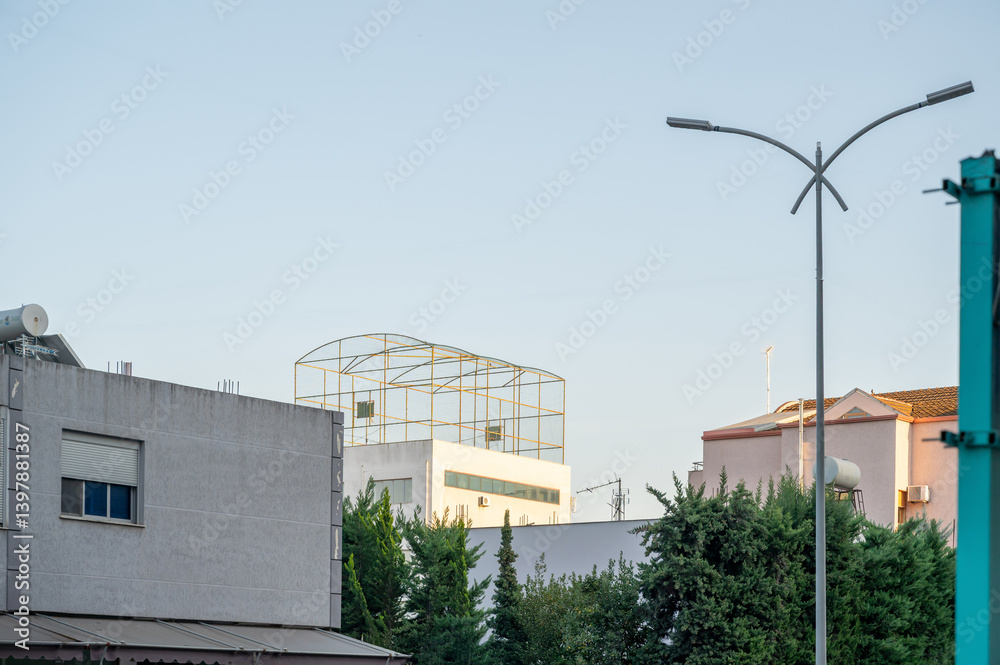 Sports basketball court on the roof of the house, fenced with a net.