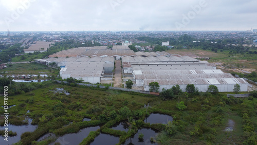 Aerial view of a goods distribution warehouse lined up with goods trucks parked in front of the warehouse