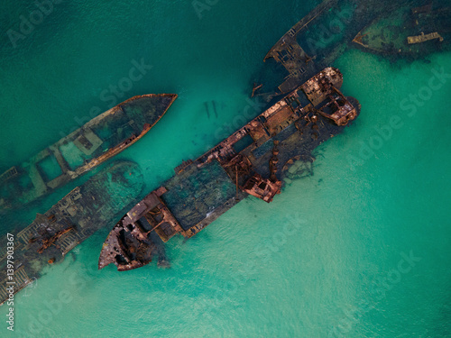 Aerial view of a scenic shipwreck submerged in turquoise waters with a beautiful coastline, Moreton Island, Queensland, Australia.