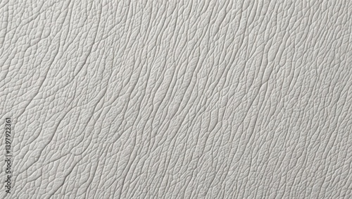 Close-up of a light gray leather texture with fine creases and natural patterns