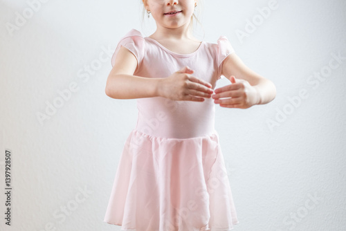young aspiring ballerina, 5 years old, dances in soft pink leotard, embodying childhood passion, elegance, and artistic expression