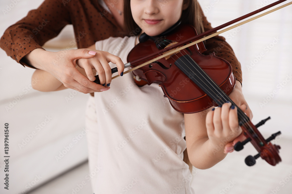 Woman teaching teenage girl to play violin at music lesson, closeup Woman teaching teenage girl to play violin at music lesson, closeup