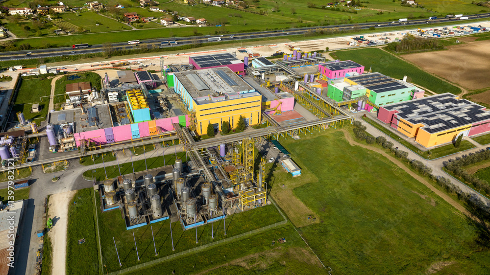 Aerial view of a large colorful factory. The warehouses have walls of different colors.
