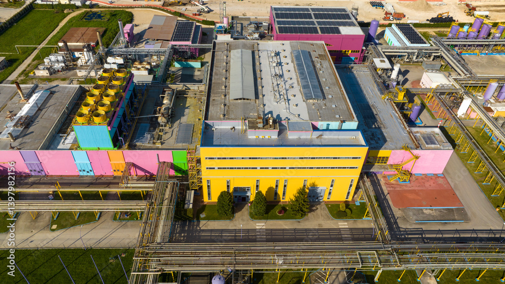 Aerial view of a large colorful factory. The warehouses have walls of different colors.