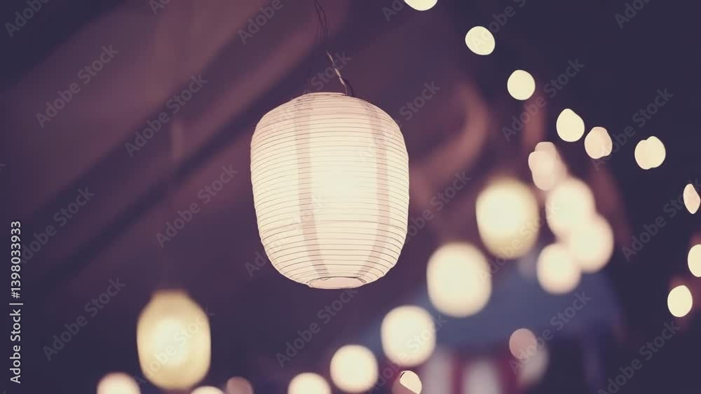 Illuminated paper lantern hangs at night market