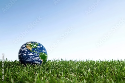 Obraz na płótnie A globe resting on lush green grass under clear blue sky, symbolizing environmental awareness and sustainability. image evokes sense of harmony between nature and planet w salonie
