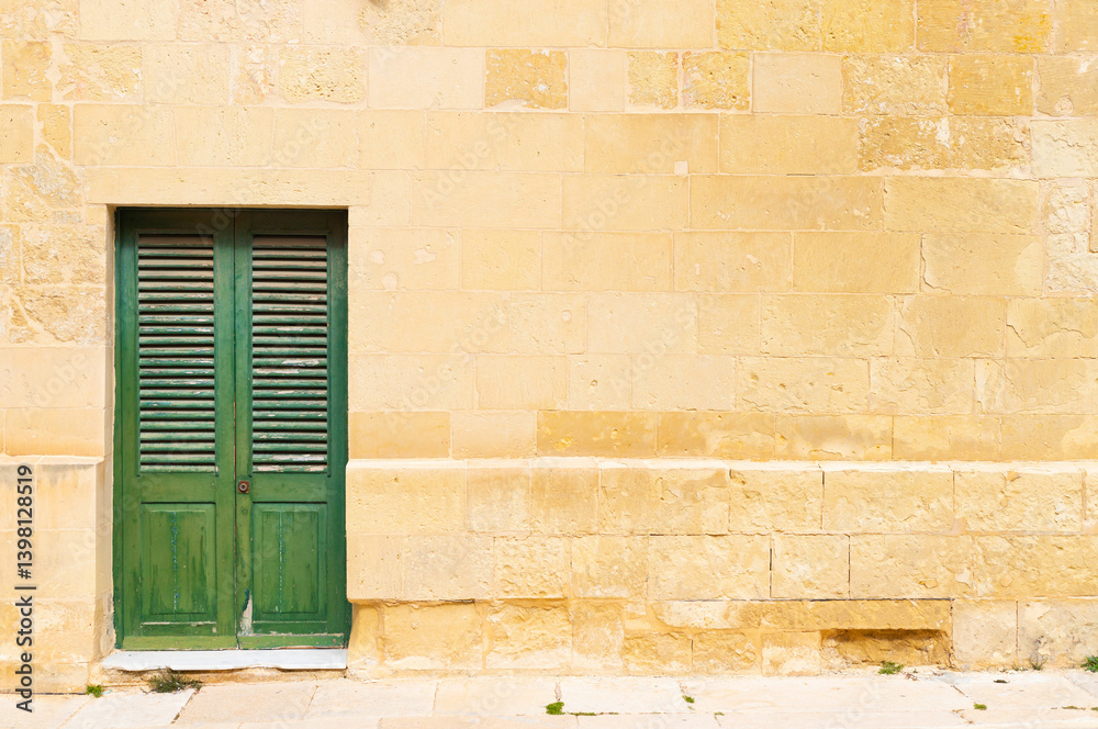 Stone brick wall with a green wooden door
