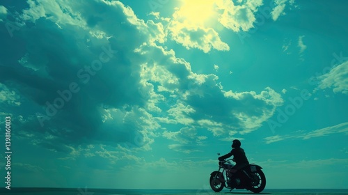 A silhouette of a motorcyclist cruising along a coastal road under a dramatic sky at sunset